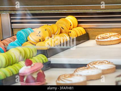 Mehrfarbige Macarons mit verschiedenen Füllungen in der Dessertauslage Stockfoto