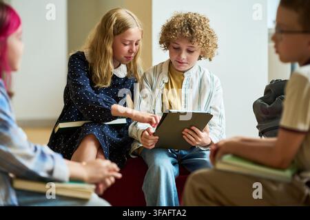 Kinder, die ein digitales Tablet während eines interaktiven Schulunterrichts verwenden Stockfoto