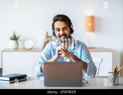 Remote-Job. Lächelnder Arabischer Mann Hotline Manager In Headset Posing Am Arbeitsplatz Stockfoto