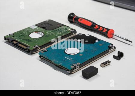 Nahaufnahme von Laptop-Festplatten und Werkzeugen auf einer Werkbank für Datenrettungs- oder Hardware-Wartungsdienste. Stockfoto