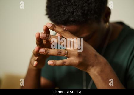 Junger afroamerikanischer Mann, der den Kopf in den Händen hält und Stress oder Angst zeigt. Bild stellt psychische Probleme dar, geeignet für Therapie- und Beratungsdienste, Nahaufnahme Stockfoto