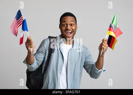 Emotionaler schwarzer Mann mit Rucksack, der verschiedene Flaggen zeigt Stockfoto