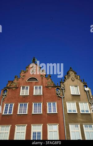 Vertikale Aufnahme von farbenfrohen, kunstvollen historischen Giebeln in der Altstadt von Danzig, Polen, vor einem lebendigen tiefblauen Himmel. Stockfoto