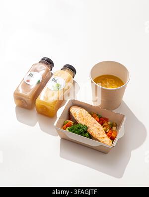 Gesunde Lachs-Mahlzeitbox mit Suppe und Smoothies Stockfoto