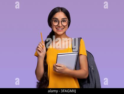 Indische Frau mit Stift und Notizbuch im Purple Studio Stockfoto