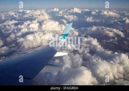 Flügelansicht eines Flugzeugs, das von London nach Berlin fliegt, mit Wolken darunter und etwas Landschaft im Osten Englands. Stockfoto