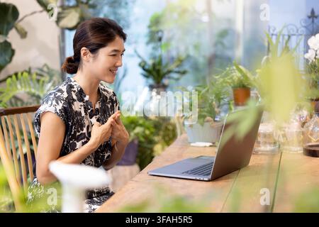 Südkoreanische Frau, die während eines Online-Videotelefonats auf einem Laptop Gebärdensprache verwendet Stockfoto