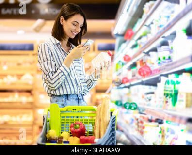 Frau Scannen Code auf Produkten mit Smartphone Stockfoto