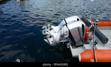Zwillings-Honda-Außenbordmotoren montiert an einem orangefarbenen RIB-Motorboot, das auf blauem Meerwasser im Hafen von Rijeka, Kvarner-Bucht, Kroatien schwimmt. Stockfoto