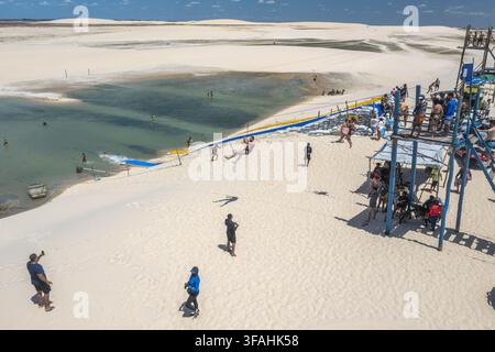Drohnenblick auf Menschen auf der Seilrutsche-Lagune, die durch Regenwasser zwischen den Dünen gebildet wird Stockfoto