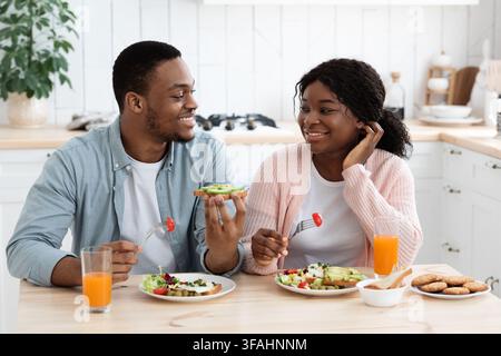 Junge Schwarze Zärtliche Paar Essen Leckeres Essen Und Im Chat Küche Stockfoto
