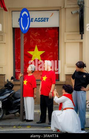 Älteres Paar in roten T-Shirts mit vietnamesischem Stern, posiert für ein Foto, Nationaltag Hanoi Stockfoto