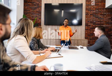 Geschäftsfrau hält Präsentation vor einem vielfältigen Team in einem modernen Büro Stockfoto