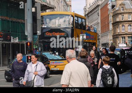 Ein gelber City Explorer Open-Top-Tourbus fährt an historischen Gebäuden vorbei mit Passagieren in Liverpool, UK. Stockfoto