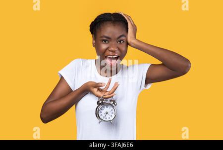 Schockiert Afrikanisch Amerikanische Frau Holding Uhr Posiert Über Gelben Hintergrund Stockfoto