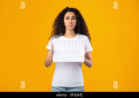 Traurige Frau Hält Leere Werbung Brett Über Gelben Hintergrund Stehen Stockfoto