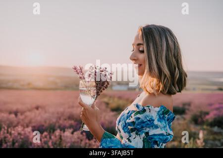Lavendel-Frau Sonnenuntergang junge Frau hält ein Glas mit Lavendelflowern in einer blühenden Wiese während der goldenen Stunde Stockfoto