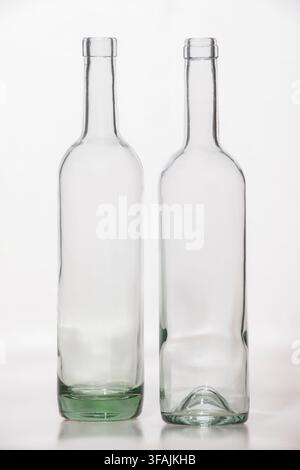 Zwei transparente leere Glasflaschen isoliert auf weißem Hintergrund, klare Verpackungsbehälter mit unterschiedlichen verkürzten Perspektiven Stockfoto