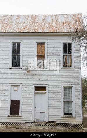Ein altes Bauernhaus im Texas Hill Country hat bessere Tage gesehen. Seine abblätternde Farbe und zerbrochenen Fenster zeigen, dass es schon seit einiger Zeit leer steht. Stockfoto