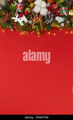 festlich dekorierter Weihnachtskranz mit Rentier und Zuckerstange auf Feiertagsszene, Ansicht von oben, rote, grüne, goldene und weiße Farben Stockfoto