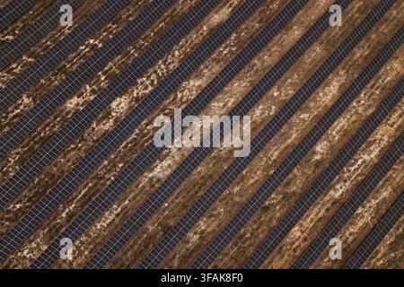 Luftaufnahme von Reihen von Solarpanelen, die auf aridem, trockenem Boden in einer großen Solarfarm in Portugal installiert sind. Stockfoto