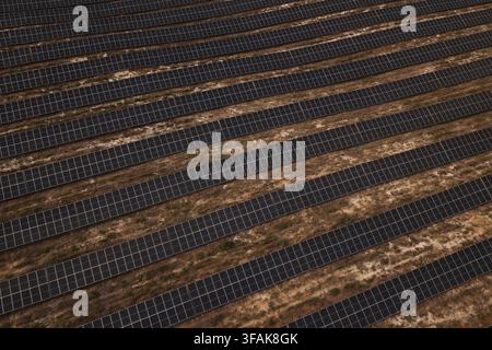 Luftbild von Reihen von Solarpanelen, die auf aridem Land in einer großen Solarfarm in Portugal installiert sind. Stockfoto