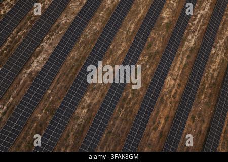 Luftbild von langen Reihen von Solarpanelen, die auf aridem, trockenem Boden in einem großen Solarkraftwerk in Portugal installiert sind. Stockfoto