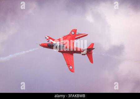 Royal Air Force Red Arrows Hawk-Jets führen ein enges Überkreuzungsmanöver während einer Flugshow durch. Stockfoto