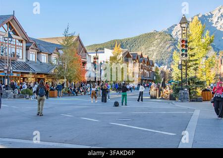 BANFF, ALBERTA, KANADA – 07. OKTOBER 2023: Eine lebhafte Straßenszene an einer Fußgängerzone auf der Banff Avenue, mit Menschen, die Fotos machen, Alpi Stockfoto