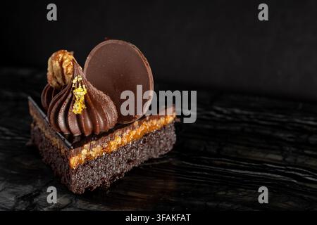 Nahaufnahme eines üppigen, schokoladigen Turtle-Brownie-Desserts auf dunklem Hintergrund Stockfoto
