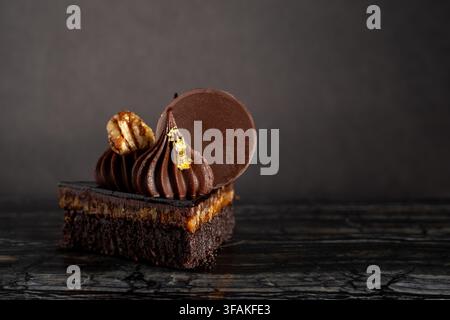Nahaufnahme eines üppigen, schokoladigen Turtle-Brownie-Desserts auf dunklem Hintergrund Stockfoto