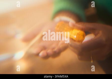 Schwarze Frau gießt Pillen aus einem Rezeptfläschchen in die Hand Stockfoto