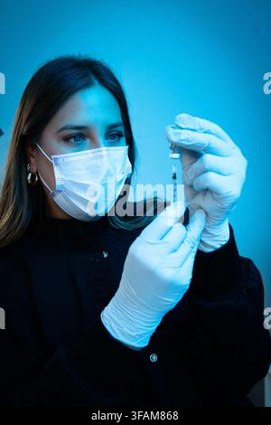 Ärztin, die Medizin in eine Spritze zieht Stockfoto