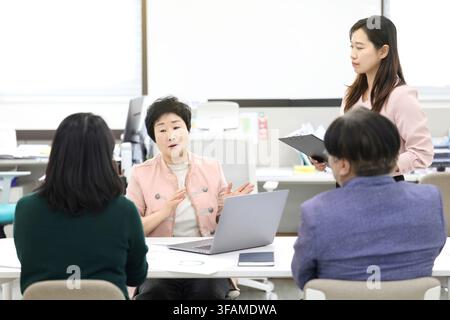 Senior-Koreanische-Frauenmanagerin leitet eine Teambesprechung in einem modernen Büro Stockfoto
