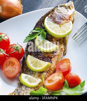 Der gebratene Fisch wird auf dem Teller serviert Stockfoto