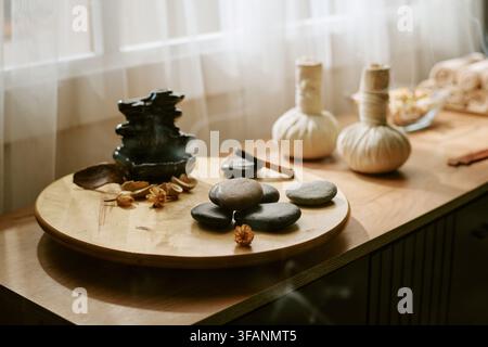 Spa-Zubehör und Massagesteine arrangiert auf Holztablett Stockfoto