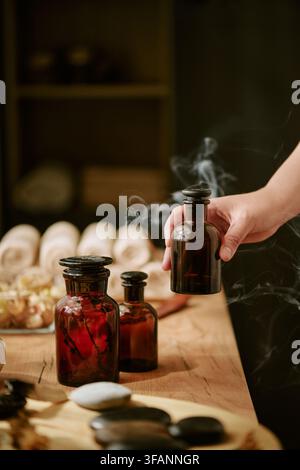 Frau hält eine Flasche mit ätherischem Öl in einem Wellness-Spa-Salon Stockfoto