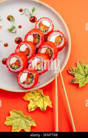 California Rolls mit rotem Tobiko und Essstäbchen Stockfoto