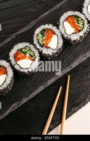 Nahaufnahme von Lachs-Sushi-Rollen auf Schiefer Stockfoto