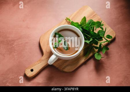 Frisch gebrühter Minztee auf einem Holzservierteller Stockfoto