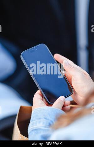 Nahaufnahme der Hände einer Frau, die ein Smartphone hält Stockfoto
