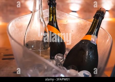 Flaschen mit Wein und Champagner, die in einem Eiskübel kühlen Stockfoto