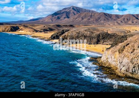 Aerial Panoramic Blick auf die goldenen Strände von Playa Papagayo und das türkisblaue Wasser, umgeben von felsigen Klippen. Besucher genießen Sonnenbad und Schwimmen unter Stockfoto