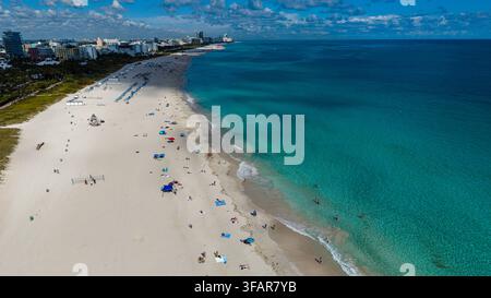 Lebendige Strandszene mit Menschen und Sonnenschirmen am South Beach Point in Miami, Florida, tagsüber Stockfoto