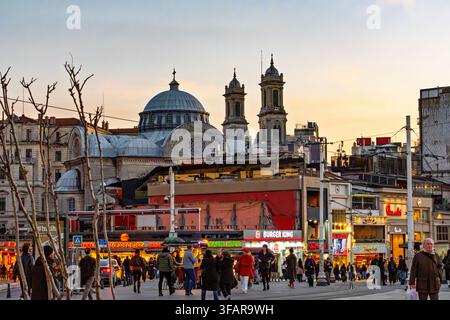 Abendliche Menschenmenge versammelt sich in der Nähe von Restaurants und Geschäften in einem belebten Gebiet am Taksim-Platz in Istanbul, Türkei Stockfoto