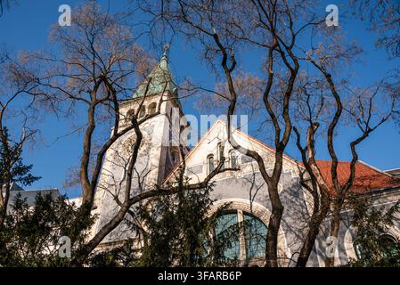 Gotische Renaissance-Kirche der Heiligen Elisabeth sichtbar durch Bäume in Bratislava mit klarem Himmel und architektonischen Details Stockfoto