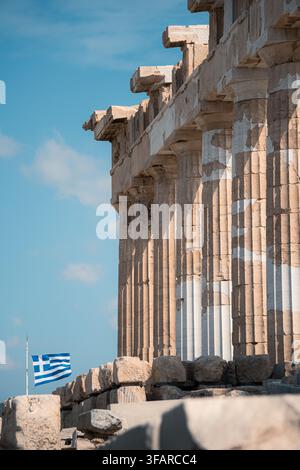 Dorische Säulen des Parthenons auf der Akropolis mit der griechischen Flagge im Hintergrund, Athen, Griechenland. Stockfoto