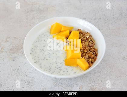 Gesunde Chia-Pudding-Schüssel mit frischem Mango und ausgeschnittenem Müsli Stockfoto