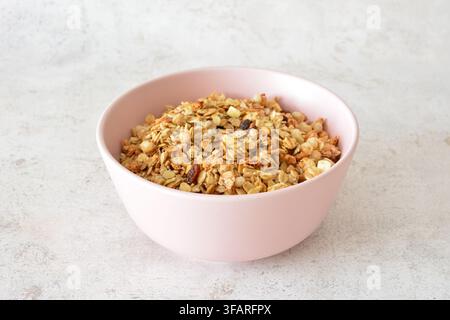 Gesunde Granola in einer rosa Schüssel isoliert auf Grau Stockfoto