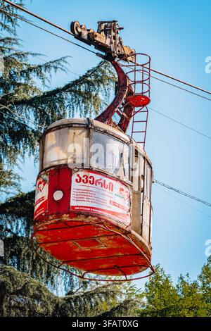 Nahaufnahme einer rostigen, nicht mehr genutzten Seilbahngondel mit einer alten Aversi-Apothekenwerbung in Chiatura, Georgien. Stockfoto
